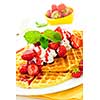 Plate of belgian waffles with fresh strawberries and whipped cream