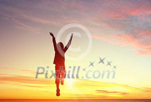 Silhouette of jumping kid boy over sunset background