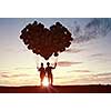 Silhouettes of guy and girl representing love and affection on sunset background