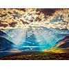 Vintage retro effect filtered hipster style image of Himalayan valley landscape with Himalayas mountains. Sun rays come through clouds. Himachal Pradesh, India