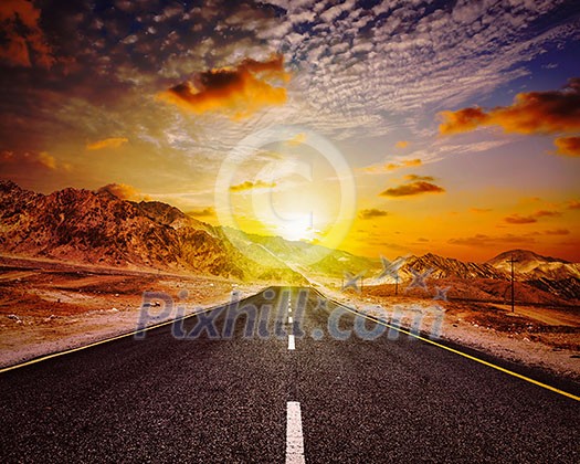 Travel forward concept background - vintage retro effect filtered hipster style image of road in Himalayas with mountains and dramatic clouds on sunset. Ladakh, Jammu and Kashmir, India