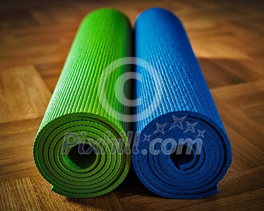 Yoga concept background - yoga mats on wooden floor