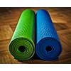 Yoga concept background - yoga mats on wooden floor