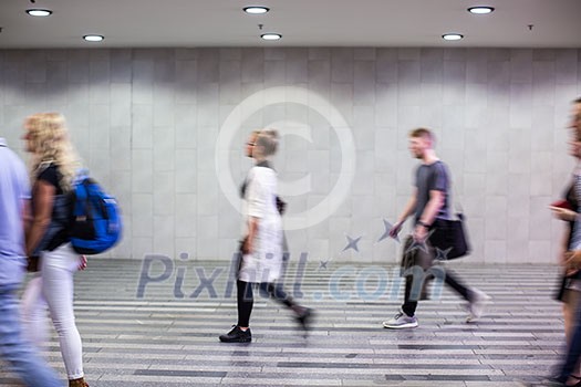 Airport rush: people with their suitcases walking along a corridor (motion blurred image; color toned image)