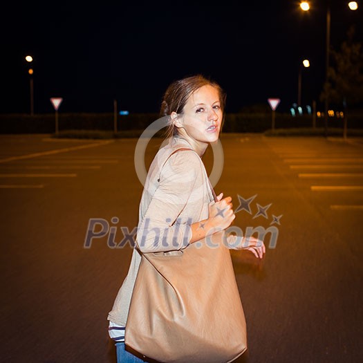 Scared young woman running from her pursuer in a deserted parking lot Scared young woman running from her pursuer in a deserted parking lot