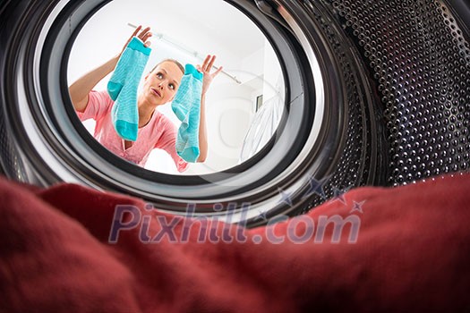 Young woman doing laundry - view from the washing machine