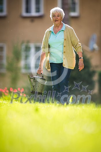 Senior woman doing some gardening in her lovely garden Senior woman doing some gardening in her lovely garden