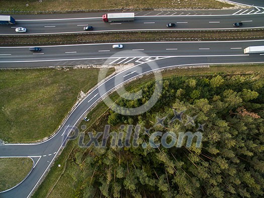 Aerial view of a highway amid fields with cars on it