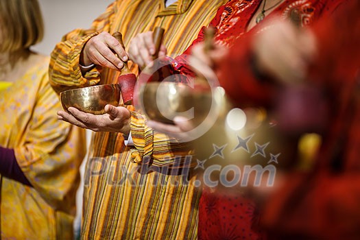 Man playing on a tibetian singing bowl (shallow DOF; color toned image) Man playing on a tibetian singing bowl (shallow DOF; color toned image)