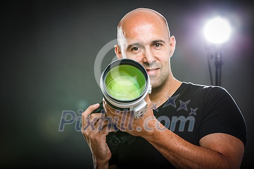 Young, pro male photographer in his studio during a photo shoot (color toned image; shallow DOF) Young, pro male photographer in his studio during a photo shoot (color toned image; shallow DOF)