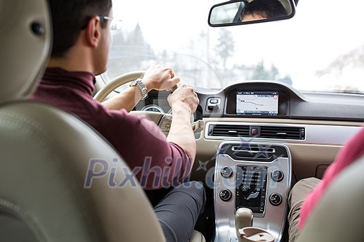 Young man driving a car with his hands on the steering wheel