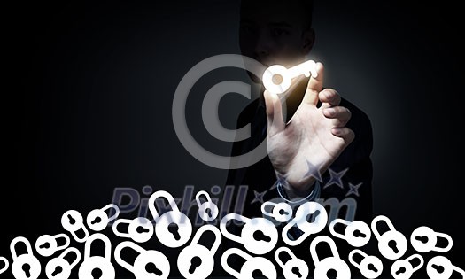 Male hand taking key glowing sign with fingers Male hand taking key glowing sign with fingers
