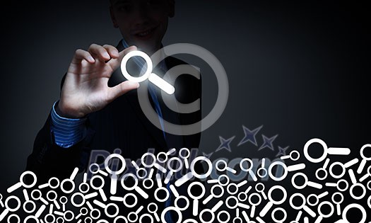 Businessman on dark background taking with fingers search icon