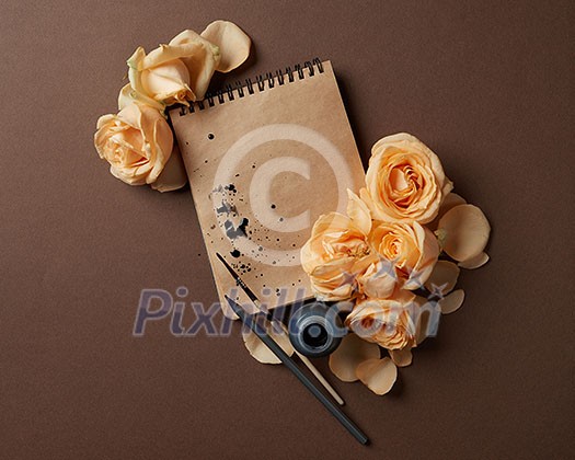 Diary or notebook with yellow roses around for ideas and expressing emotions. Blank copy space for writing congratulations., flat lay Diary or notebook with yellow roses around for ideas and expressing emotions. Blank copy space for writing congratulations., flat lay