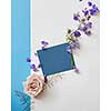greeting card of purple flowers and blue paper on a white background, flat lay