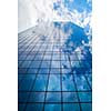 glass office building against a blue cloudy sky.