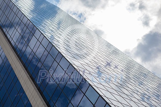 clouds reflected in windows of modern office building