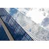 clouds reflected in windows of modern office building