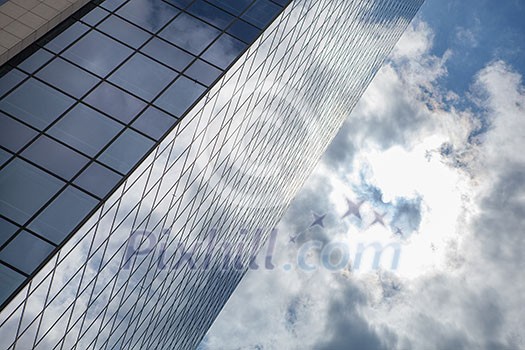 clouds reflected in windows of modern office building clouds reflected in windows of modern office building