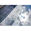 clouds reflected in windows of modern office building