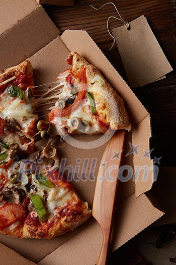 Top view of pieces of cheese pizza in paper box over wooden table Top view of pieces of cheese pizza in paper box over wooden table