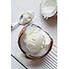 Ice cream in a half of coconut with a spoon On white wooden background