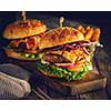 Delicious homemade hamburger on wooden background. Rustic style. Retro toned.