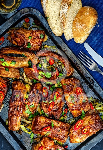 Roasted sliced barbecue pork ribs, seasoned with a spicy basting sauce and served with vegetables Roasted sliced barbecue pork ribs, seasoned with a spicy basting sauce and served with vegetables