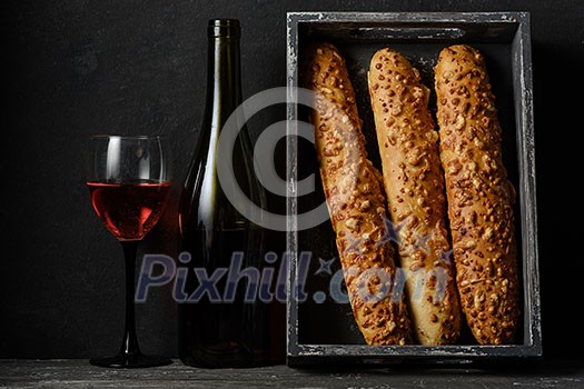 French cheese baguette with a red wine. Homemade freshly baked french baguettes. Rustic style. Long bread.