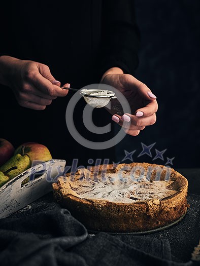 Young girl sprinkled with powdered sugar apple pie. Life style.