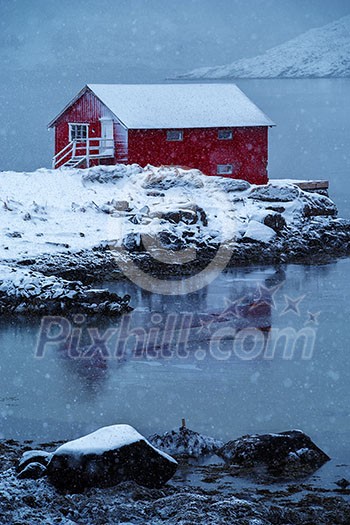 Red rorbu house in Norway in the seashore