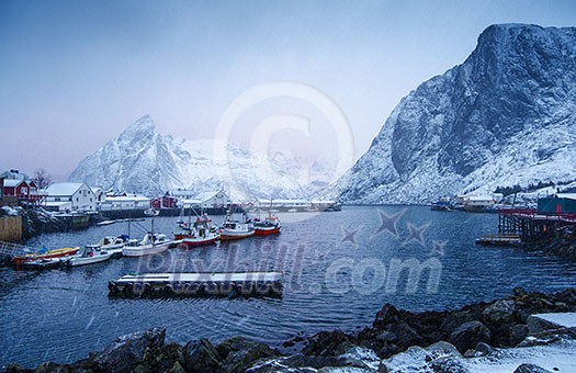 Cold and snowy winter morning in Hamnoy, with houses, boats and mountains.