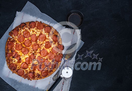 Homemade Pepperoni Pizza over black background. Top view.
