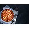 Homemade Pepperoni Pizza over black background. Top view.
