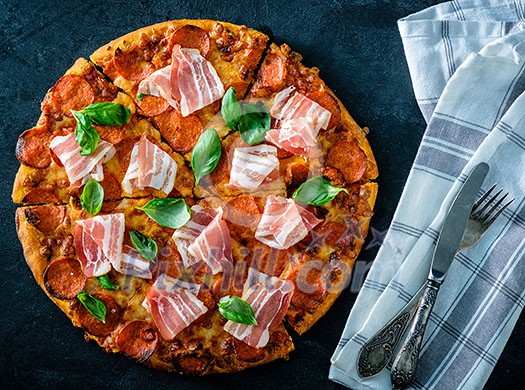 Homemade Pepperoni Pizza with fresh bacon over black background. Top view. Homemade Pepperoni Pizza with fresh bacon over black background. Top view.