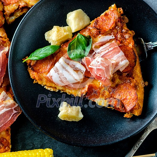 Homemade Pepperoni Pizza with fresh bacon over black background. Top view.