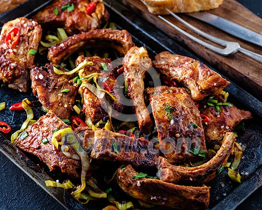 Roasted sliced barbecue pork ribs, seasoned with a spicy basting sauce and served with vegetables Roasted sliced barbecue pork ribs, seasoned with a spicy basting sauce and served with vegetables