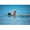 Young man swimming the front crawl in the sea (swimmer, triathlon)