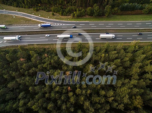 Aerial view of a highway amid fields with cars on it Aerial view of a highway amid fields with cars on it