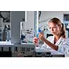 Portrait of a female researcher doing research in a lab, using a tablet computer for data collection and visualization(shallow DOF; color toned image)