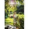 Pretty, young woman gardening in her garden, cutting branches, preparing the orchard for the winter