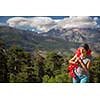 Pretty, female hiker in high mountains packing her backpack