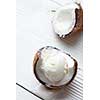Half of coconut with fresh ice cream ball On a wooden white background