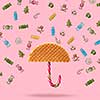 Umbrella made of waffle and Christmas candy on a pink background.