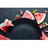 slices of watermelon placed in a circle of black plate. Space for text