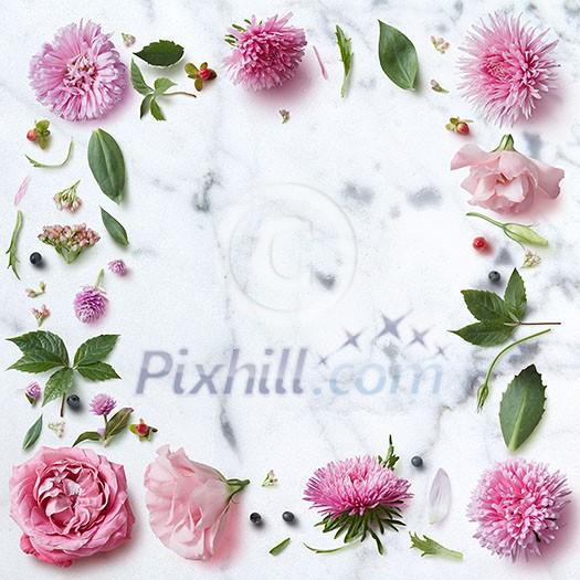 Frame of spring flowers on a white marble background with space for text