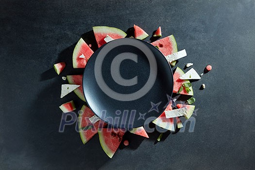 slices of watermelon placed in a circle of black plate. Space for text slices of watermelon placed in a circle of black plate. Space for text