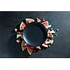 slices of watermelon placed in a circle of black plate. Space for text