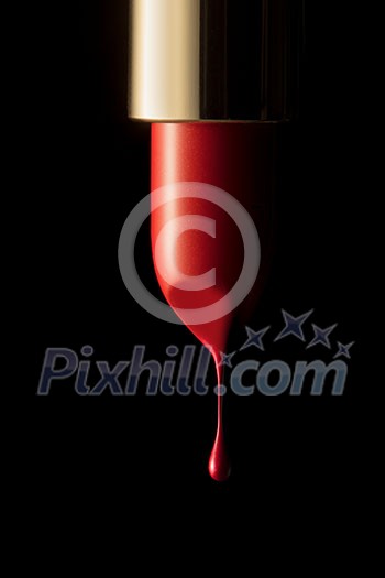 Red melting lipstick isolated on black background