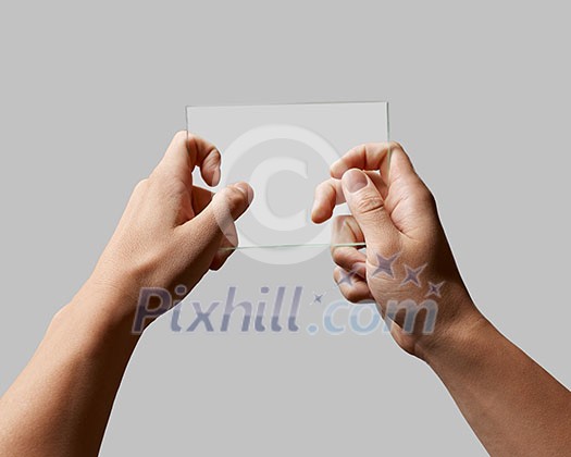 rectangular transparent glass in male hands on a gray background place for text rectangular transparent glass in male hands on a gray background place for text